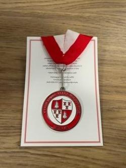 Photo of Commemorative Zipper Pull with a red and white ribbon