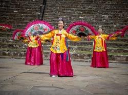 身着中国传统服装的妇女手持扇子跳舞.