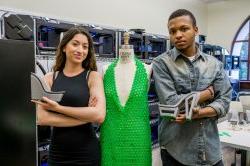 男女学生穿着3D打印的绿色连衣裙和灰色鞋子摆姿势