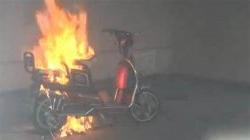 Photo of an electric scooter on fire while charging indoors.