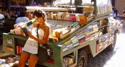 在一个热带国家，靠在卡车上的女人变成了移动图书馆