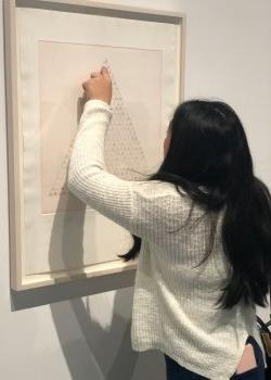 student studying piece of artwork