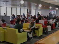 Students sitting on the third floor of the Student Center studying and having conversations.