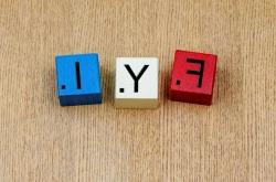 一张木桌上的三个木块. 每个方块代表一个字母，就像在拼字游戏中使用的那样:F Y I.
