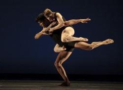 Photo of two dancers, one supporting the other, in dramatic pose.